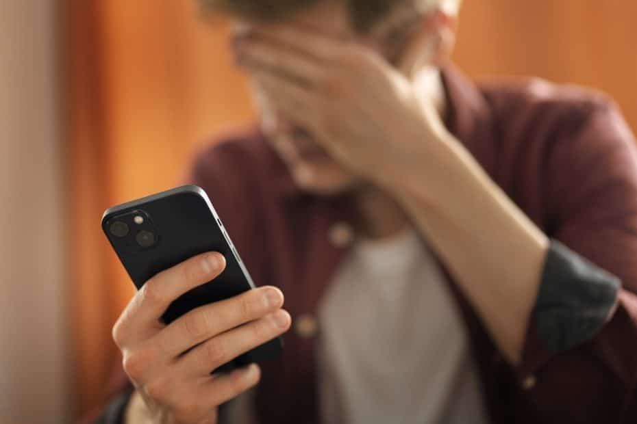 Homem agoniado com o celular
