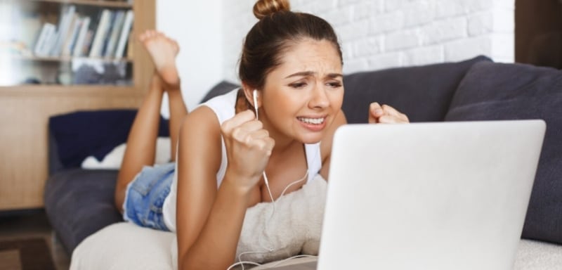 Mulher comemorando diante do notebook