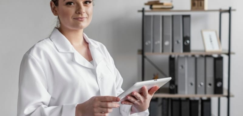 Mulher com jaleco e um tablet